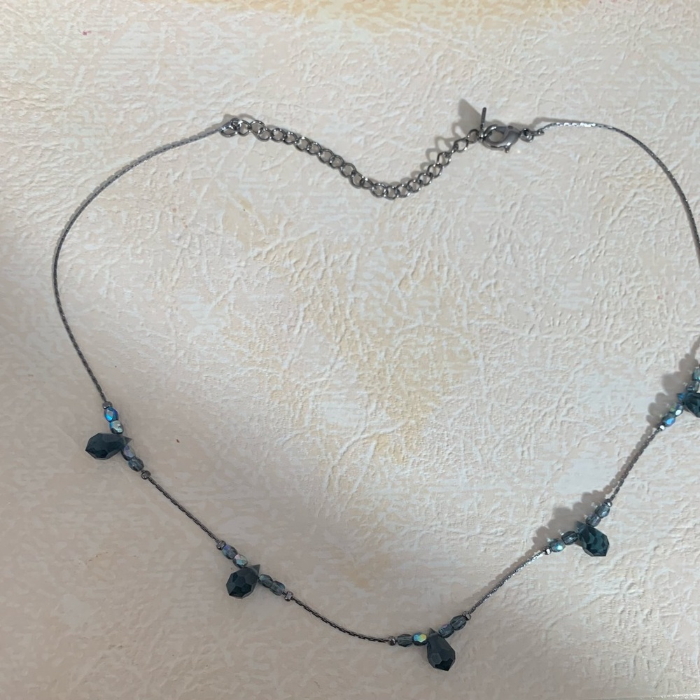 Crystal beads interspersed on gunmetal gray.  Maker stamp on tag is unidentified